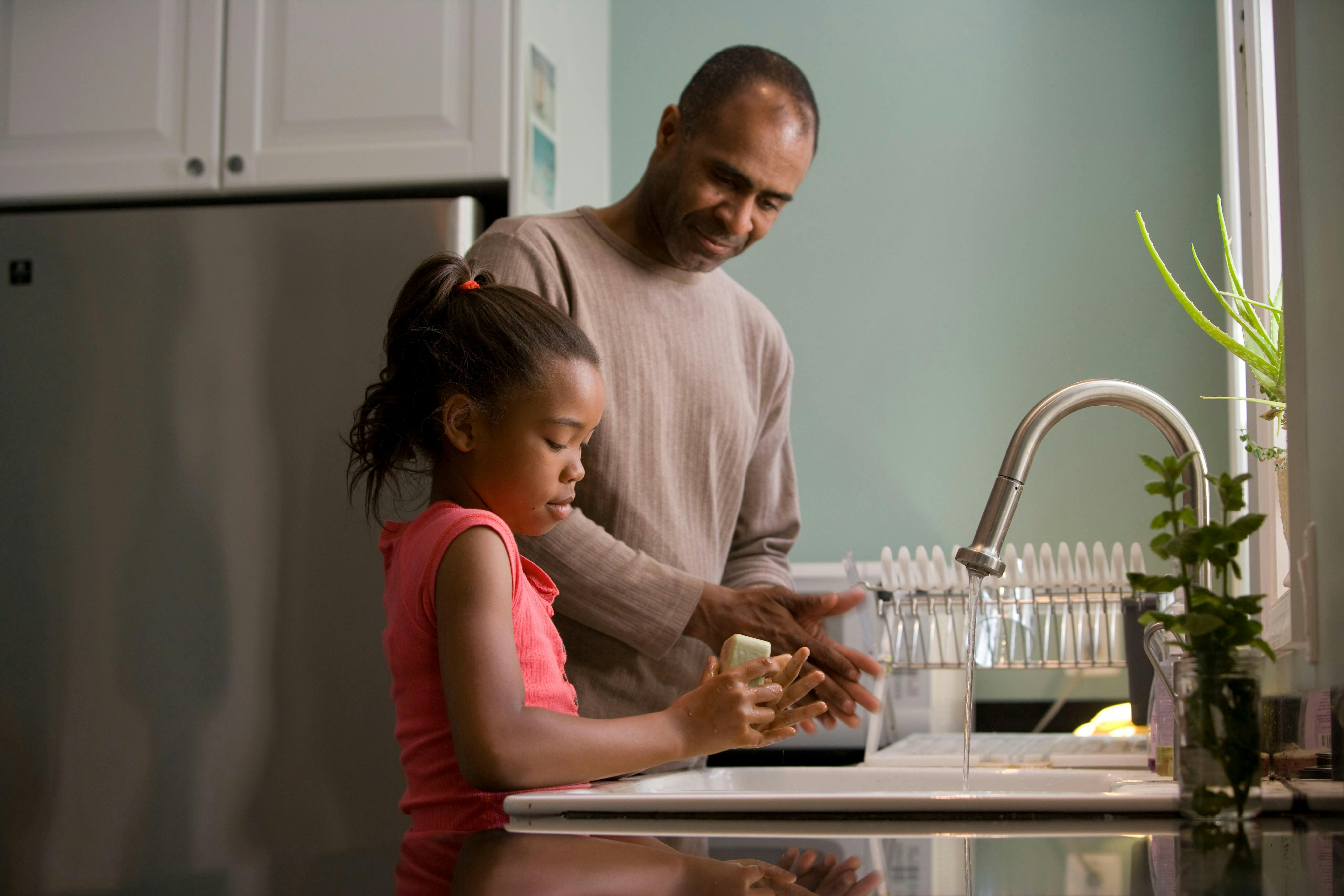 Father and daughter at kitchen sink