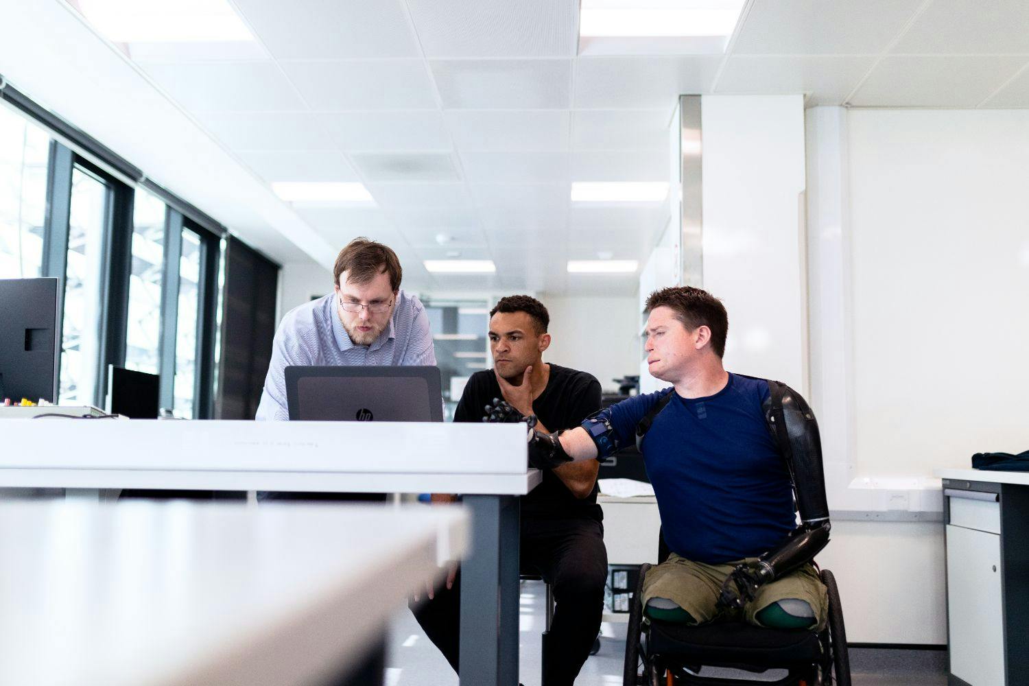 worker with prosthetic limbs with colleagues