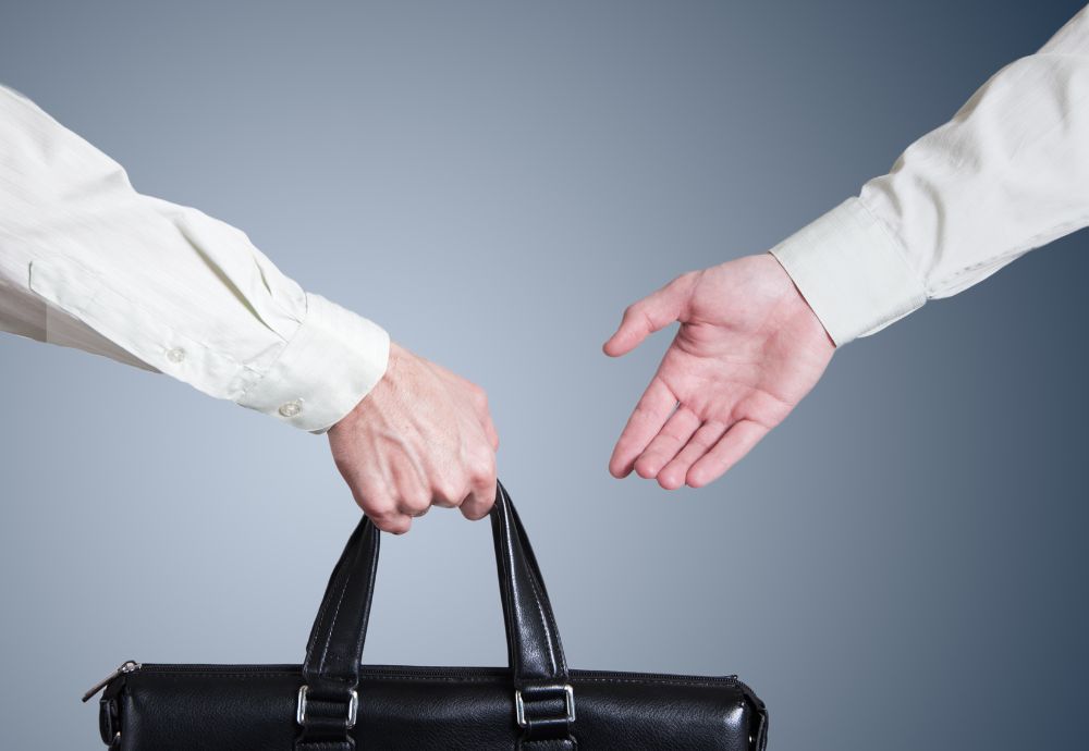 2 people handing over a bag of work a process documents