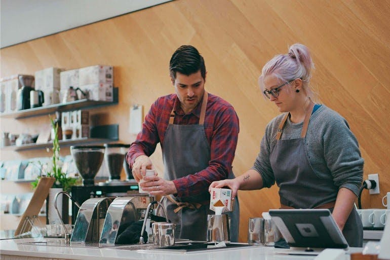 Manager training employee in a coffee shop